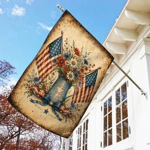 May include: A rectangular garden flag featuring a vintage-style beige background with a blue pitcher filled with red, white, and blue flowers. Two American flags are displayed behind the pitcher, which is decorated with a white star and blue bow.