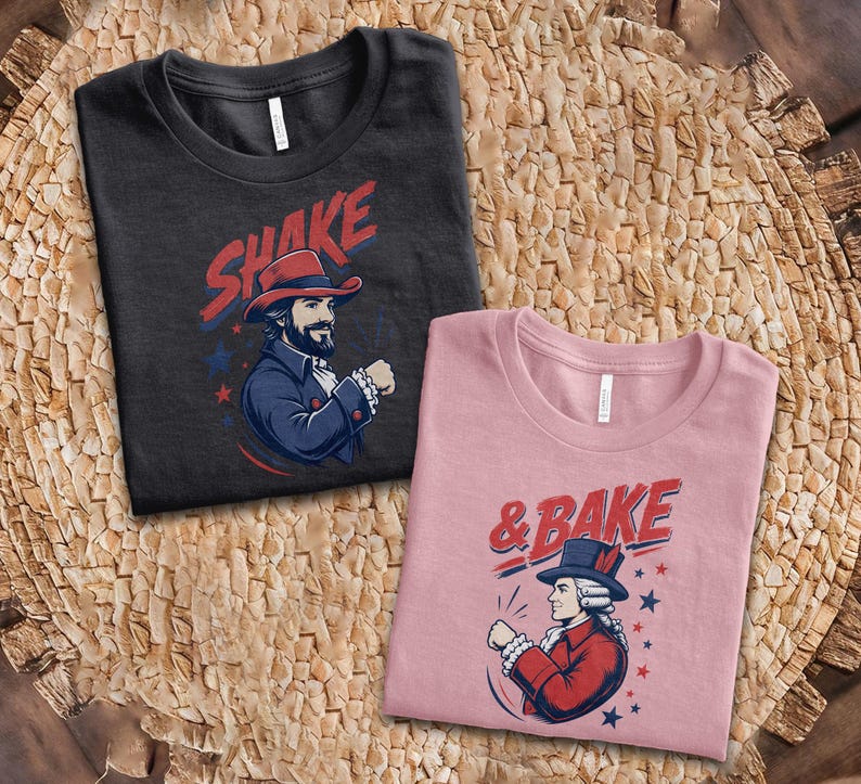 May include: A black t-shirt featuring a graphic of a man in a colonial hat with the text SHAKE and a pink t-shirt featuring a graphic of a person in a colonial hat with the text & BAKE, both decorated with blue and red stars and accents.