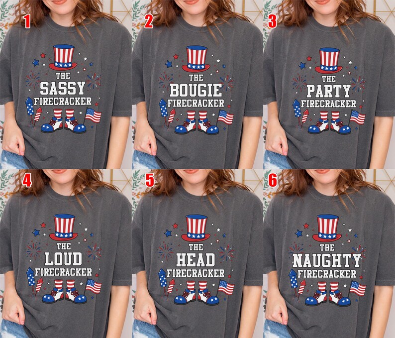 May include: A charcoal gray t-shirt featuring a graphic with a red, white, and blue top hat, fireworks, a small American flag, and shoes. The text reads THE SASSY, BOUGIE, PARTY, LOUD, HEAD, or NAUGHTY FIRECRACKER, depending on the specific numbered option.