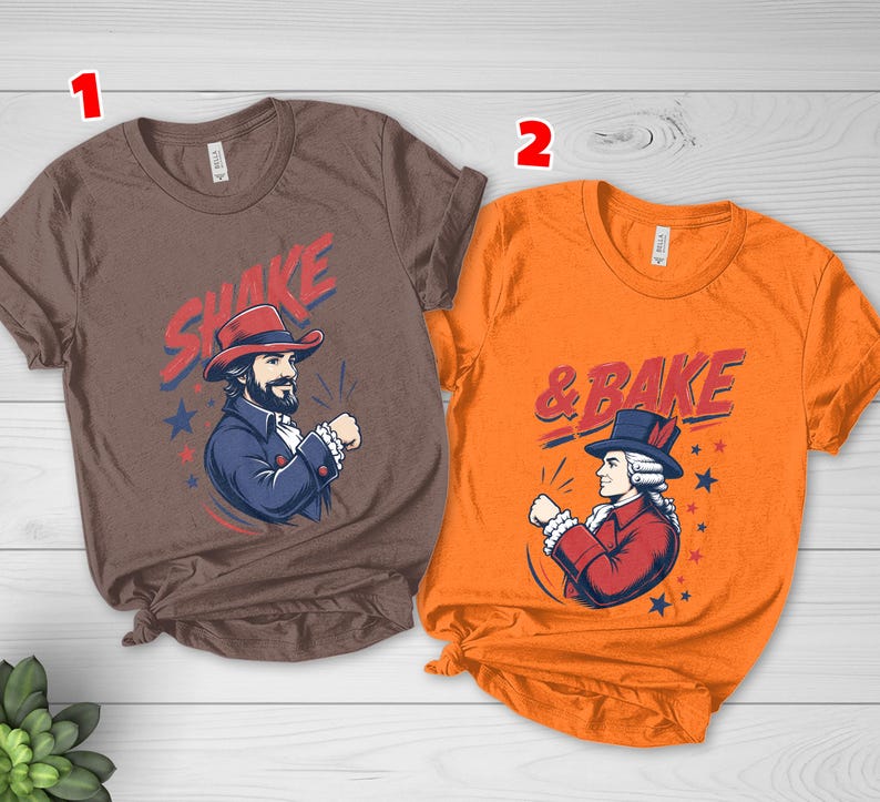 May include: A brown t-shirt with the text SHAKE and a graphic of a person in a red hat and blue coat, and an orange t-shirt with the text & BAKE and a graphic of a person in a blue hat and red coat, both featuring star accents.