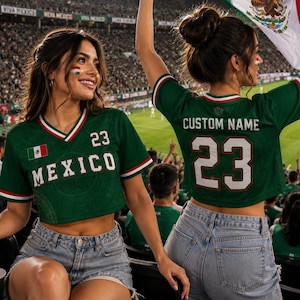 May include: A dark green cropped jersey featuring the word MEXICO and the number 23 on the front, with a small Mexican flag emblem. The back displays the text CUSTOM NAME above the number 23. The jersey has white and red trim on the V-neck and sleeves.
