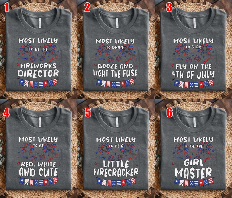 Puede incluir: Una colecci&oacute;n de seis camisetas gris oscuro, cada una con texto blanco y gr&aacute;ficos de fuegos artificiales y banderines en rojo, blanco y azul. Las camisetas muestran frases como Most Likely to be the Fireworks Director y otras variantes.