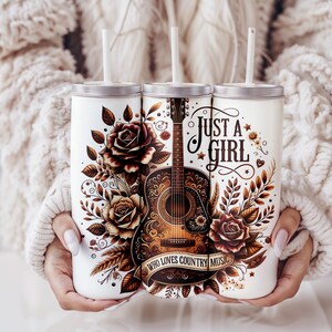 Puede incluir: Tres vasos de acero inoxidable con tapas y pajitas. Los vasos presentan un dise&ntilde;o floral con rosas y una guitarra. El texto en el vaso dice "Just a Girl Who Loves Country Music".