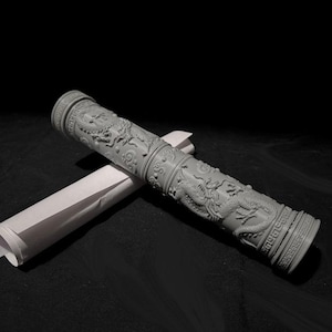 May include: A gray, cylindrical object with intricate carvings of dragons and other mythical creatures. The object is made of a smooth, hard material and has a slightly textured surface. It is lying on a black surface.