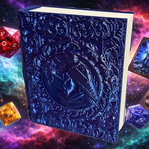 May include: A dark blue, embossed book with a raven design on the cover. The book has ornate floral and scrollwork patterns. Dice and trading cards are scattered around the book against a colorful galaxy background. The book's pages are white.