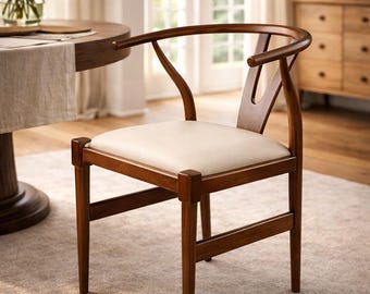 Silla Wishbone de mediados de siglo: silla auxiliar de comedor de madera maciza con respaldo curvo y asiento tapizado.