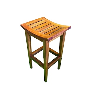 May include: A wooden bar stool with a curved seat made of horizontal slats. The stool has a square base with a footrest and four legs. The wood has a warm, natural tone, and the stool is set against a white background.