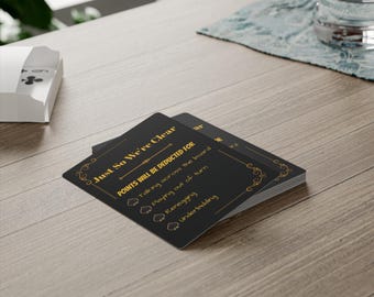 May include: A black card with gold lettering that reads "Just So We're Clear" and lists points that will be deducted for certain actions during a game. The actions listed are talking across the board, playing out of turn, reneging, and underbidding.