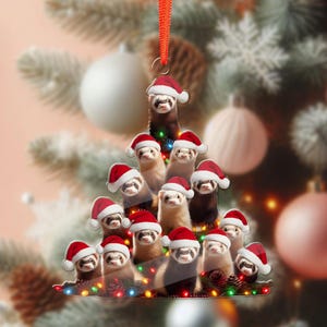 May include: A Christmas tree ornament featuring a festive design. The ornament is shaped like a Christmas tree, composed of ferrets wearing Santa hats. The ornament is decorated with colorful lights and a red ribbon for hanging.