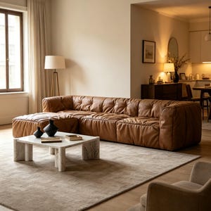 Könnte beinhalten: Ein modernes Wohnzimmer mit einem großen, braunen Ledersofa. Ein Marmor-Couchtisch mit schwarzen Vasen und einer kleinen Box steht auf einem Teppich in neutralen Tönen. Eine Stehlampe und ein Fenster mit Vorhängen sind sichtbar.