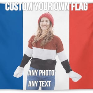 Op de afbeelding: Een aangepaste vlag met de tekst "CUSTOM YOUR OWN FLAG" bovenaan. Het vlagontwerp toont een vrouw met een rode hoed en trui, met de tekst "ANY PHOTO ANY TEXT" onderaan. De vlag heeft blauwe, witte en rode verticale strepen.