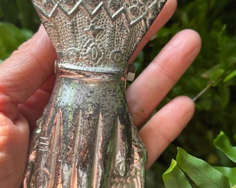 May include: A silver metal hand-shaped paperclip with an ornate design. The paperclip is in the shape of a hand with five fingers and a detailed floral pattern on the top.