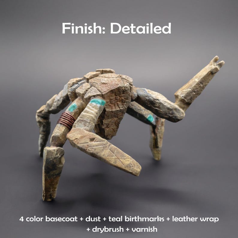 May include: A multi-legged stone-like creature figurine with a textured tan and brown surface. It features teal accents, a copper-colored wire wrap on one limb, and the text Finish: Detailed and 4 color basecoat + dust + teal birthmarks + leather wrap + drybrush + varnish.