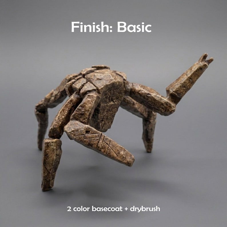 May include: A brown, textured, multi-legged creature figurine with a stone-like appearance. The text "Finish: Basic" appears at the top, and "2 color basecoat + drybrush" is printed at the bottom. The figure has segmented limbs and a shell.