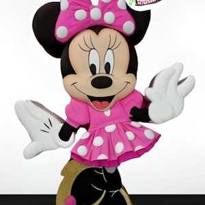 May include: A pink and white polka dot Minnie Mouse pinata with a black bow and black shoes. The pinata is standing on a white surface. The text "Minnie's Funny Birthday" is on a white circle with a colourful border.