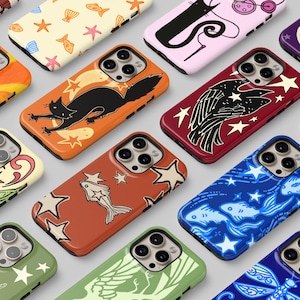 May include: A collection of smartphone cases featuring diverse graphic patterns including ladybugs, cats, fish, stars, and celestial motifs in various colors such as orange, red, blue, green, and purple, each with a triple camera lens cutout.