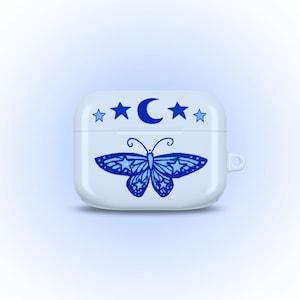 May include: White AirPod case with a blue butterfly design. The case features a crescent moon and stars at the top. The butterfly has intricate wing patterns. The case has a smooth, glossy finish.