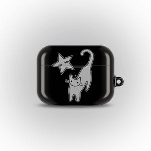 May include: Black AirPod case featuring a white illustration of a cat and a star. The cat is arched with its tail up, and the star has a closed eye. The case has a small loop on the side.