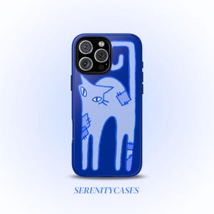 May include: A blue phone case featuring a light blue cat illustration with stitched patches. The cat has a stylized design with a curved tail and is set against a gradient background. The text "SERENITYCASES" is at the bottom.