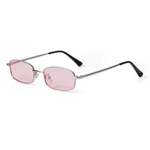 May include: Rectangular sunglasses with a silver frame and pink lenses. The temples are silver with black tips. These stylish sunglasses offer a retro aesthetic.