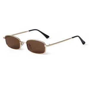 May include: Rectangular sunglasses with a gold-colored frame and brown lenses. The temples are thin and gold, with black ear pieces. The sunglasses are set against a white background.
