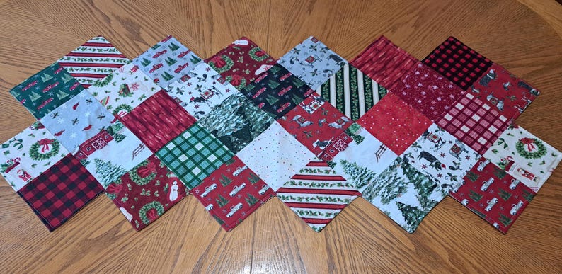 May include: A festive Christmas table runner with a patchwork design. The runner showcases various seasonal patterns, including red trucks, snowmen, Christmas trees, and plaid. The squares are arranged in a diamond pattern, creating a decorative holiday piece.