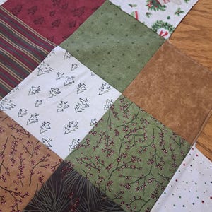 Pu&ograve; includere: Un tessuto patchwork a tema natalizio con vari motivi. I quadrati presentano disegni come alberi di Natale, bacche, strisce e stelle nei colori rosso, verde, marrone e bianco. Adatto per lavori artigianali stagionali.