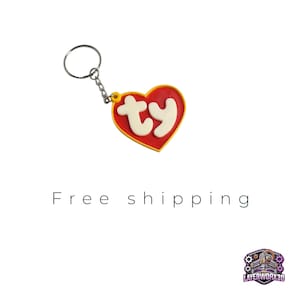 May include: Red heart-shaped keyring with a white "TY" logo. The keyring is attached to a silver key ring.