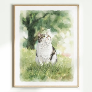 K&ouml;nnte beinhalten: Ein Aquarellbild einer grau-wei&szlig;en getigerten Katze, die in einer gr&uuml;nen Wiese sitzt. Die Katze schaut mit geneigtem Kopf nach oben. Der Hintergrund zeigt einen weichen, verschwommenen gr&uuml;nen Baum und Laub in einem hellen, luftigen Kunststil.