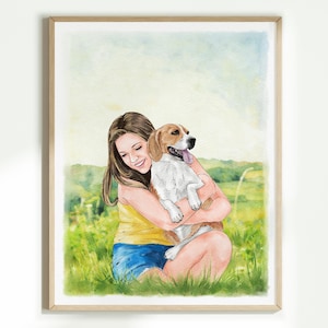 May include: Watercolour painting of a person embracing a beagle dog. The person wears a yellow vest top and blue shorts, seated in a grassy field. The dog has brown and white fur and a pink tongue. The artwork is framed in a light wood frame.