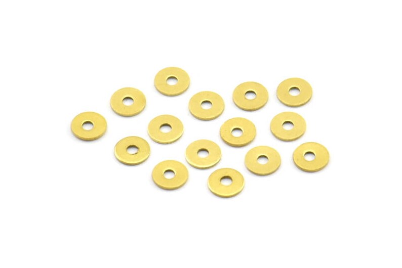 May include: A collection of 15 gold-colored metal washers. The washers are arranged in a random pattern on a white background.