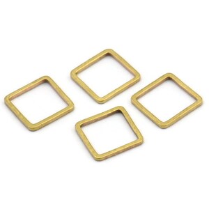 Könnte beinhalten: Vier quadratische Sprungringe aus goldfarbenem Metall. Die Ringe sind offen und haben eine rautenförmige Umrandung.