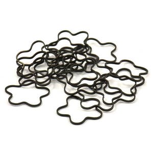 May include: A pile of black rubber hair ties shaped like flowers.