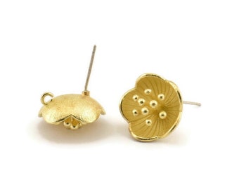 May include: A pair of gold-tone flower shaped stud earrings. The earrings have a textured surface and a small loop on the back for attaching to a post.