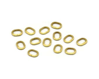 May include: A group of 14 gold oval jump rings. The rings are all the same size and are arranged in a random pattern on a white background.