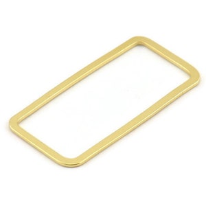Pode incluir: Um anel retangular de metal dourado com bordas arredondadas.