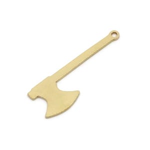 Puede incluir: Un colgante de hacha de color dorado con un pequeño lazo en la parte superior para colgar. La cabeza y el mango del hacha están claramente definidos, y el diseño general es simple y elegante. Este dije es adecuado para la fabricación de joyas.