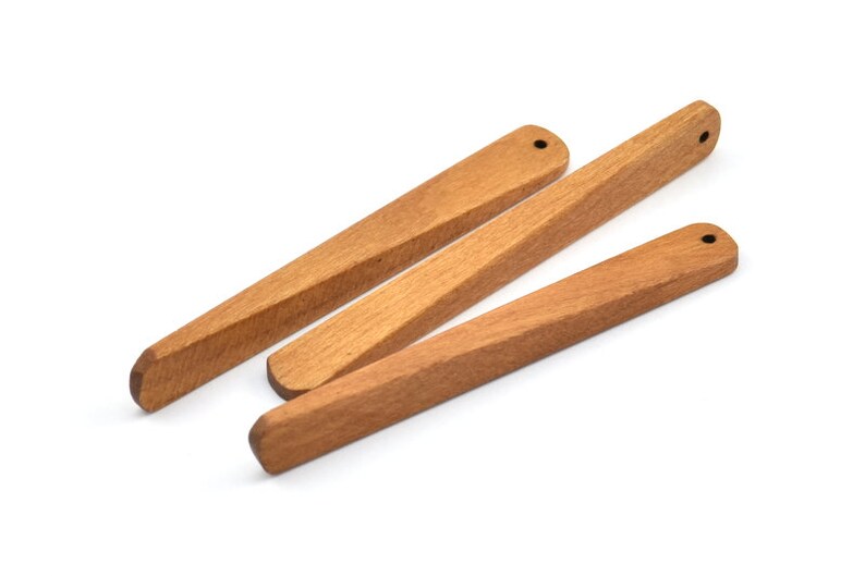 May include: Three wooden kitchen utensils with rounded ends. The utensils are made of light brown wood and have a smooth finish.