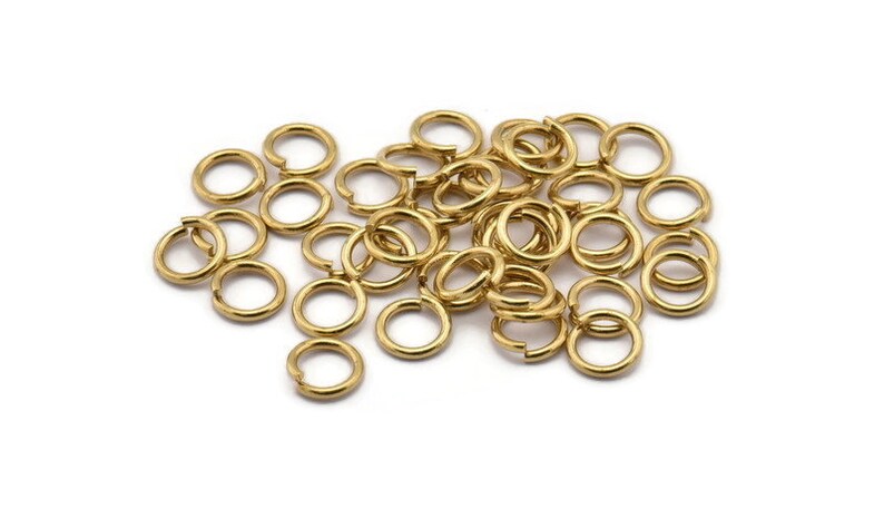 May include: A pile of gold jump rings, a type of jewelry finding used for connecting chains, cords, and other jewelry components.