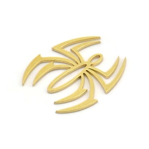 May include: A gold-colored metal spider design with intricate details. The spider is stylized and has a geometric shape.