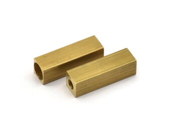 May include: Two gold-colored metal spacers, each with a square shape and a hole in the center.
