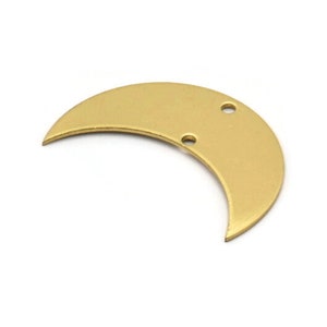 May include: A gold crescent moon charm with two holes for attaching to jewelry or other crafts.