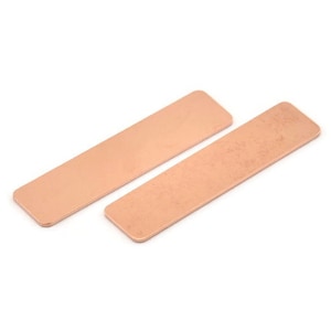 Puede incluir: Dos placas rectangulares de cobre, una es lisa y la otra tiene una superficie texturizada.