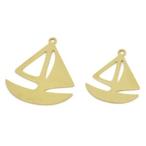 Peut inclure: Deux breloques en métal doré en forme de voilier, l'une plus grande que l'autre. Les breloques sont découpées en forme de voilier avec un design simple.
