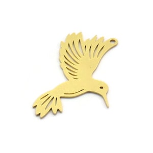 May include: A gold-colored metal hummingbird charm with intricate cut-out details. The charm is in flight with its wings spread out.