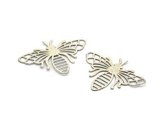 May include: Two gold metal bee-shaped charms with intricate cut-out designs. The bees have wings, a body, and a head with antennae.