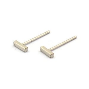 May include: A pair of silver bar stud earrings. The earrings are simple and minimalist, with a small, rectangular bar.