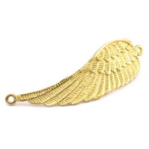 Puede incluir: Encanto de ala de metal dorado con un diseño detallado. El encanto tiene dos anillos de salto para sujetarlo a joyas.