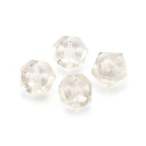 May include: Four clear glass beads with a faceted, diamond-like shape.