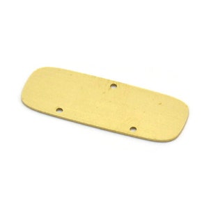 Pode incluir: Uma placa de metal dourada com bordas arredondadas e três pequenos furos.